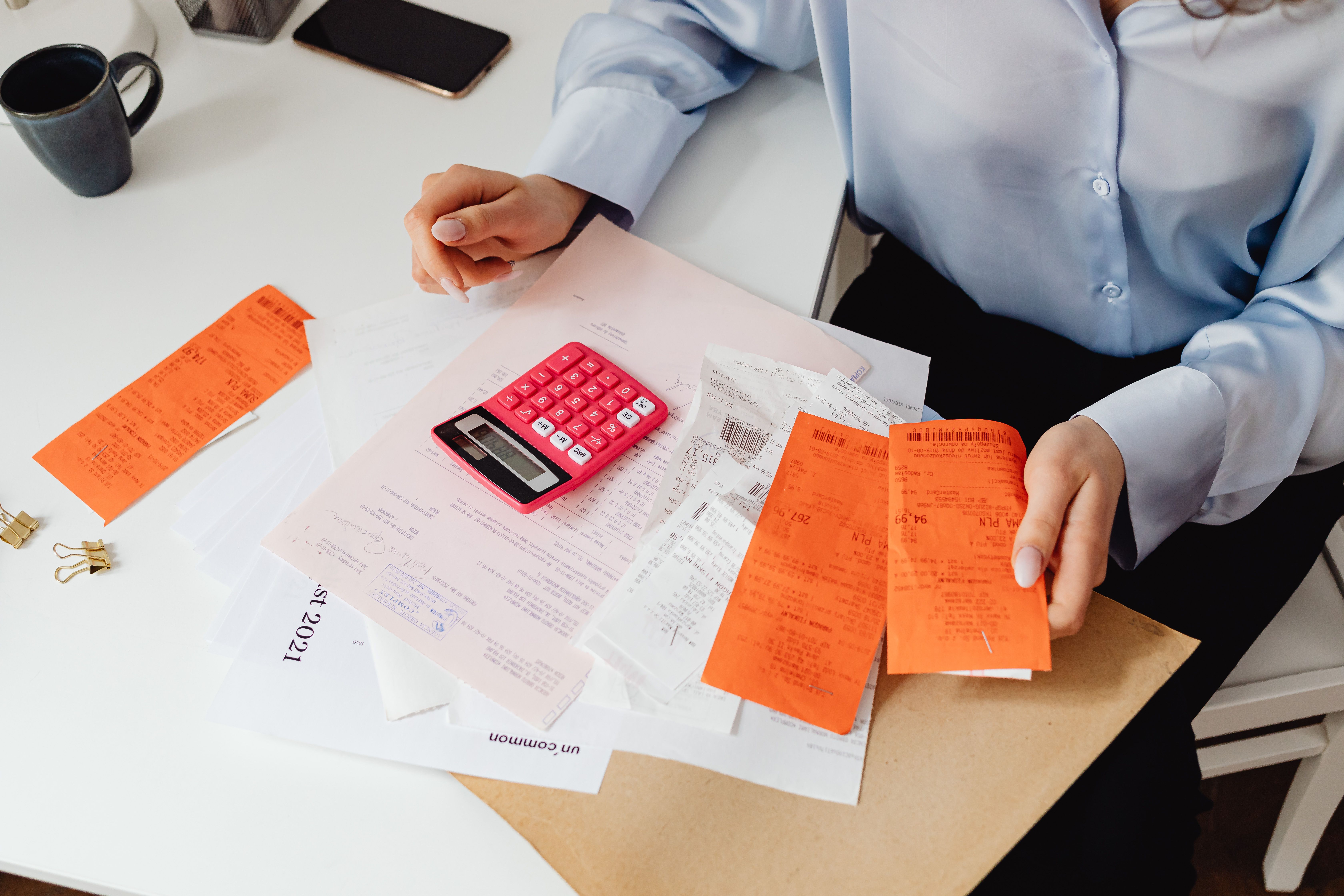 Woman reviewing receipts and calculating legal expenses at a desk.