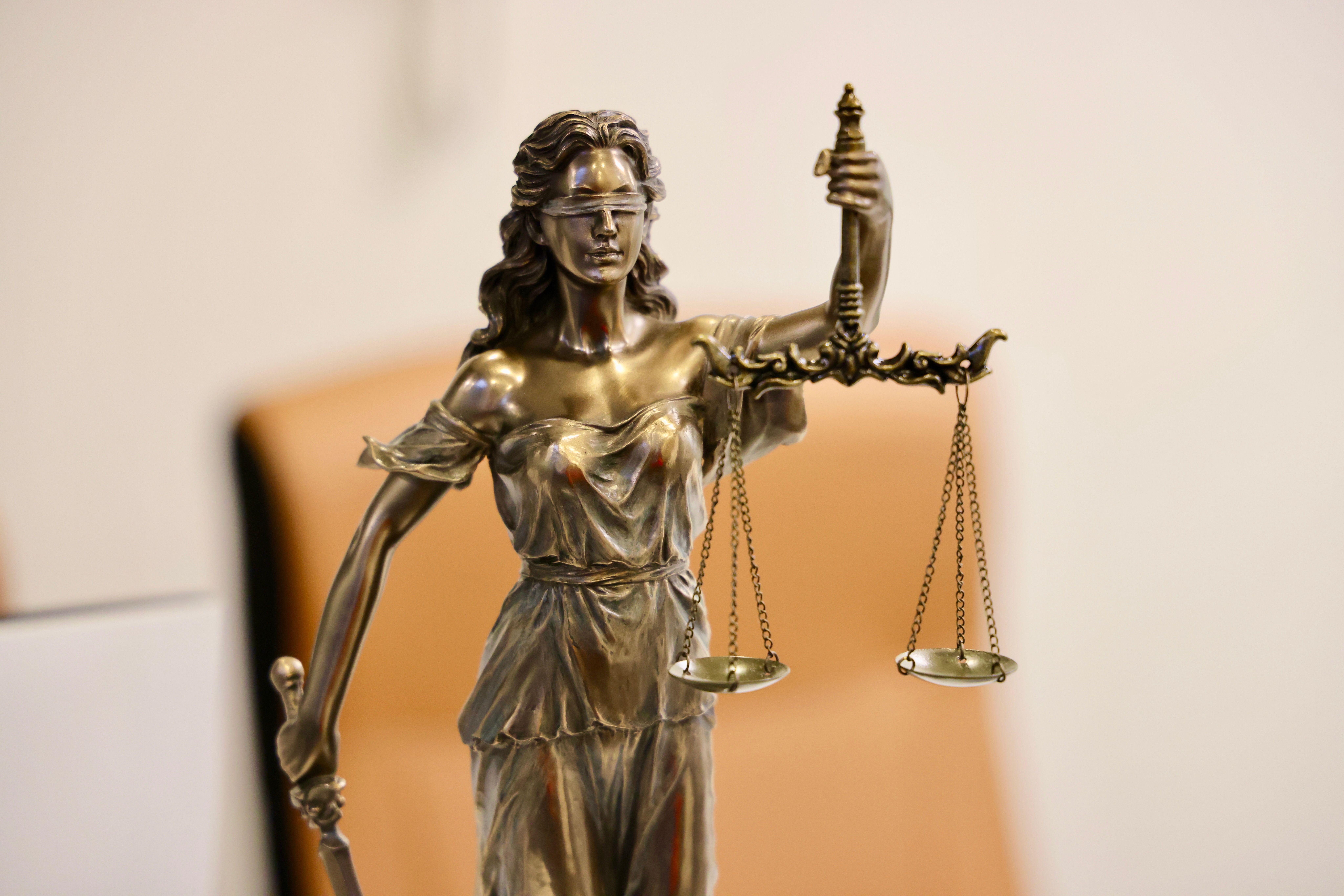 Close-up of Lady Justice holding scales, symbolizing fairness and the legal system.