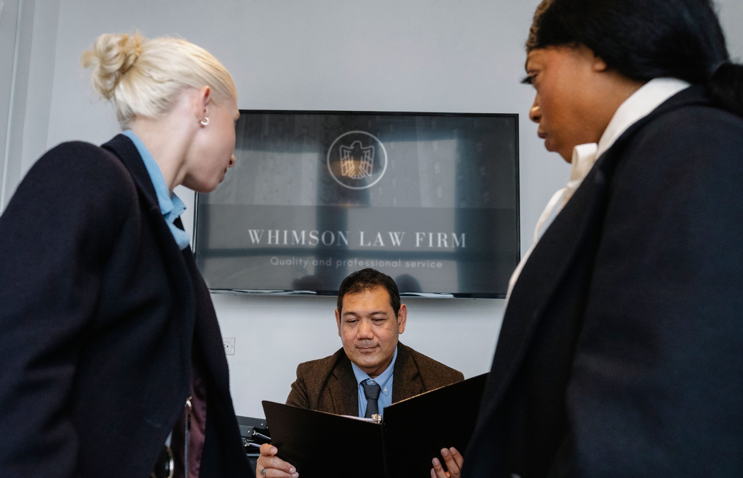Diverse team of attorneys meeting in a law firm conference room to discuss large-scale litigation strategy
