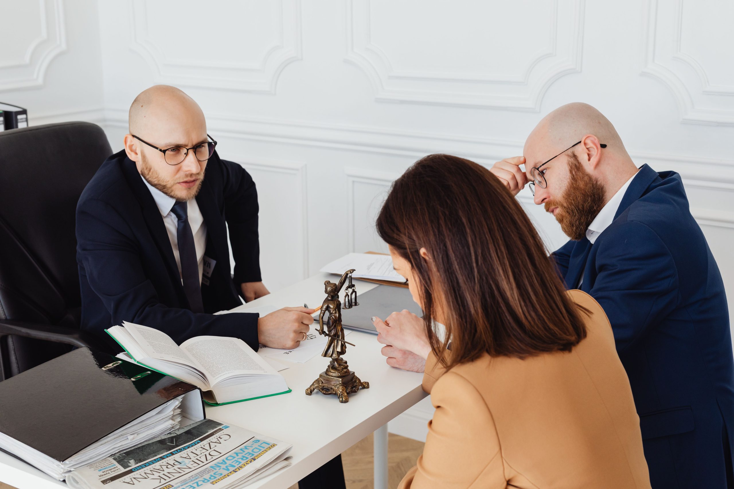 Lawyer consulting clients in a modern office about a serious legal matter.