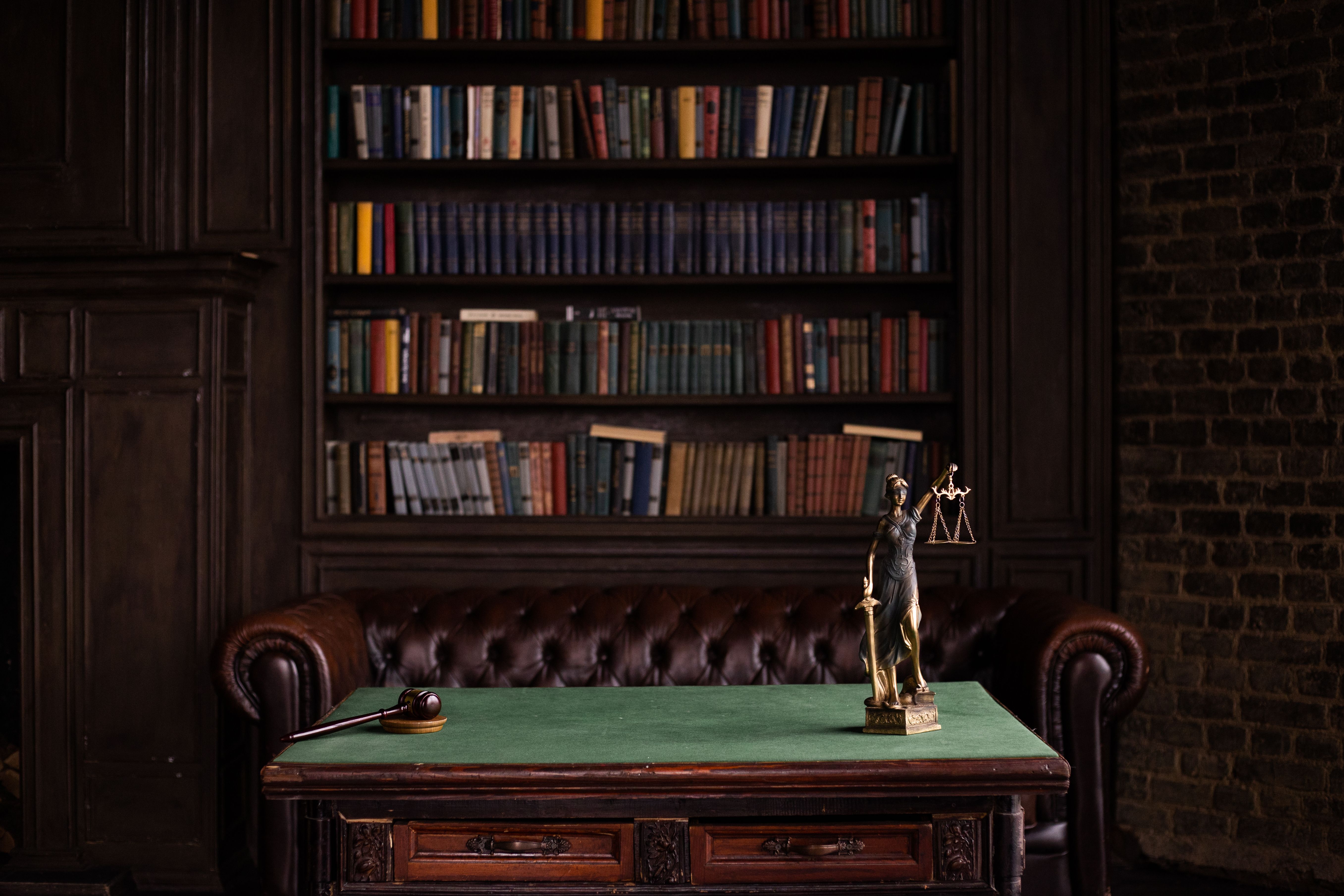 Classic legal study with shelves of law books, a gavel and a Lady Justice figurine representing legal research